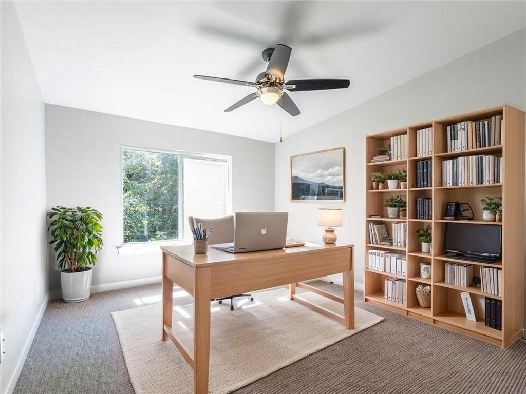Image 3: Carpeted home office featuring vaulted ceiling and