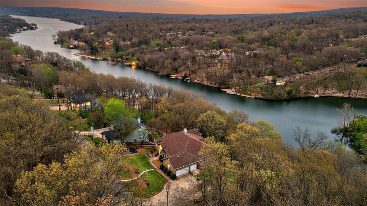Image 2: Aerial view at dusk of a water view and a forest v