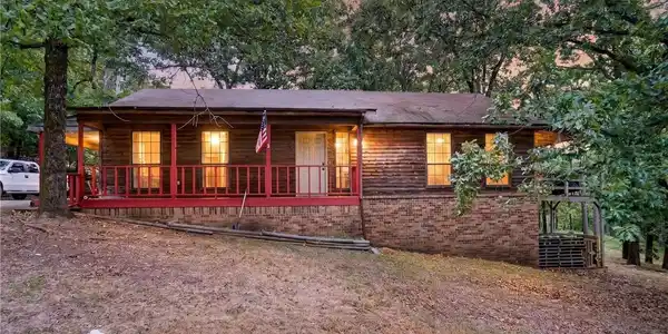 Image 2: Wood-sided home featuring a red-painted front porc