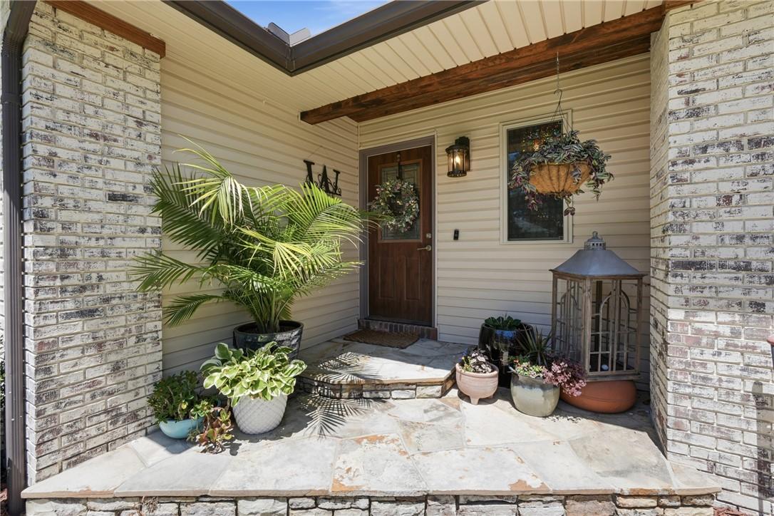 Image 4: Front entryway featuring a natural stone patio, br