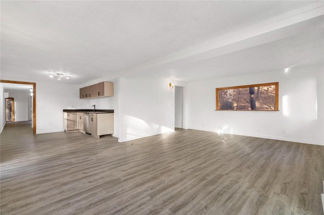 Image 4: Unfurnished living room featuring dark wood-style