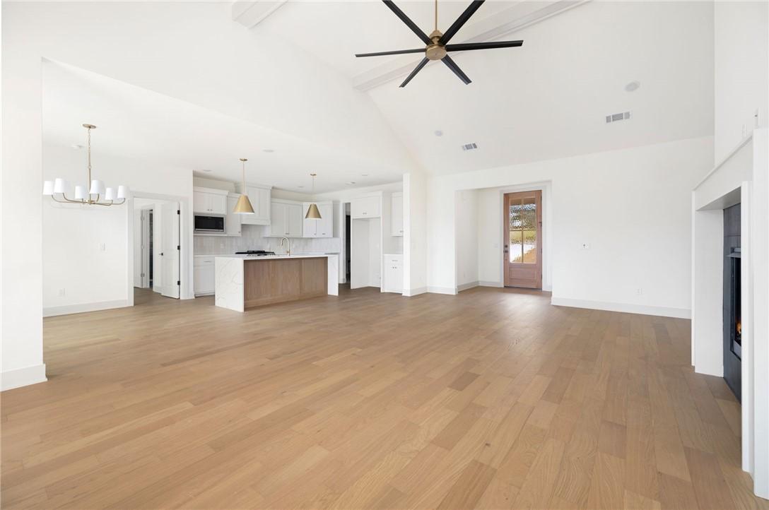 Image 4: Unfurnished living room with a warm lit fireplace,