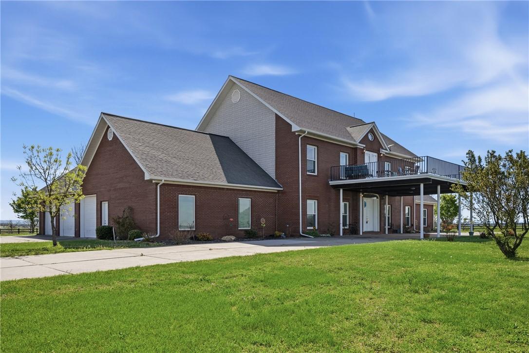 Image 4: Front view of property featuring a yard and brick