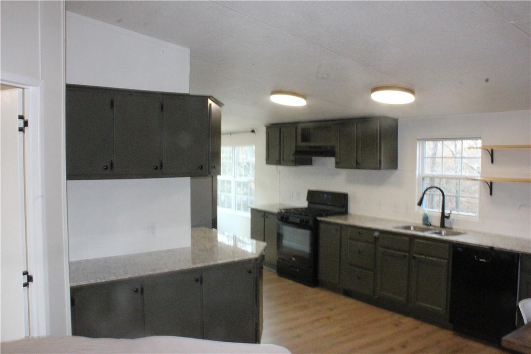 Image 4: Kitchen with black appliances, open shelves, light