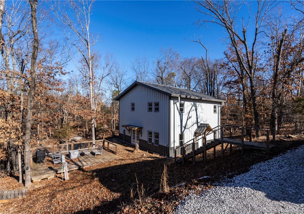 Image 2: View of side of property with a wooden deck and vi
