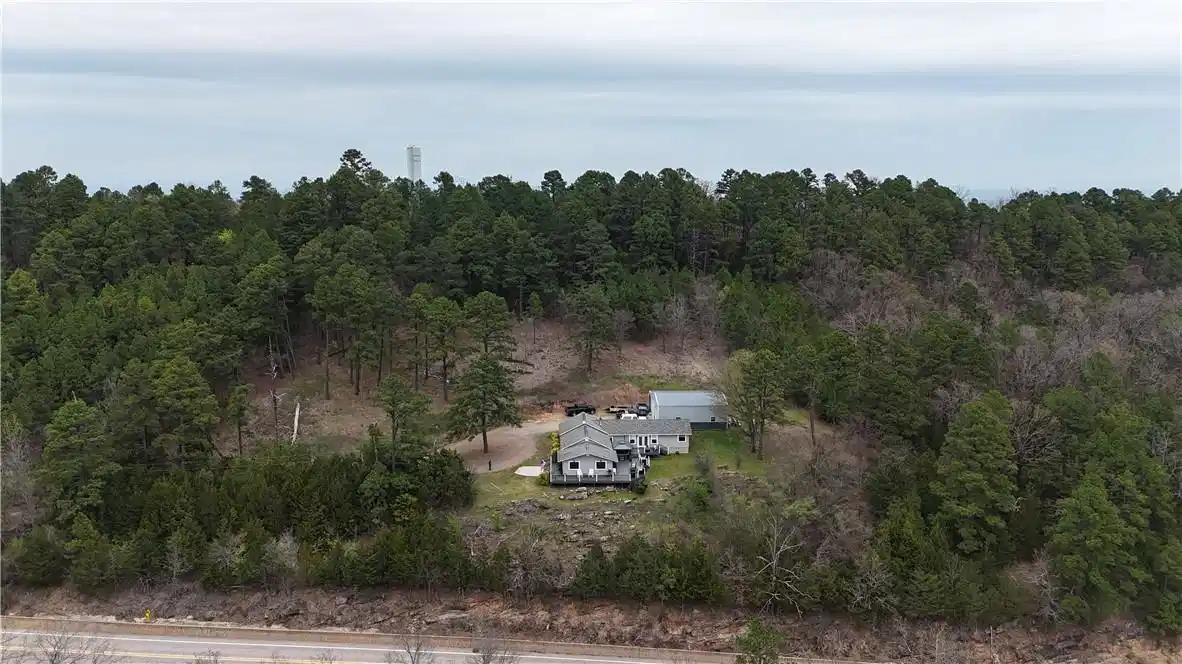 Image 1: View from above of property with a forest