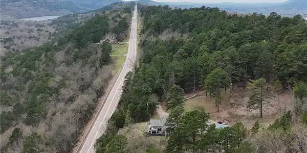 Image 3: Aerial view of a heavily wooded area and a mountai