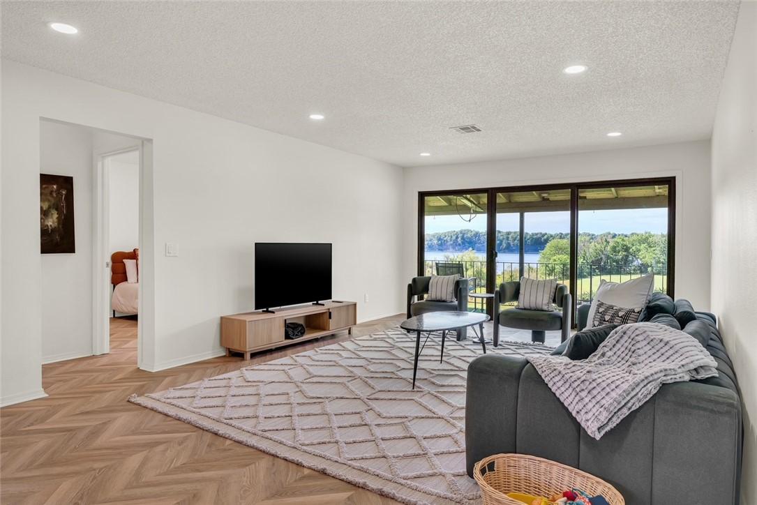 Image 2: Spacious living area featuring expansive sliding g