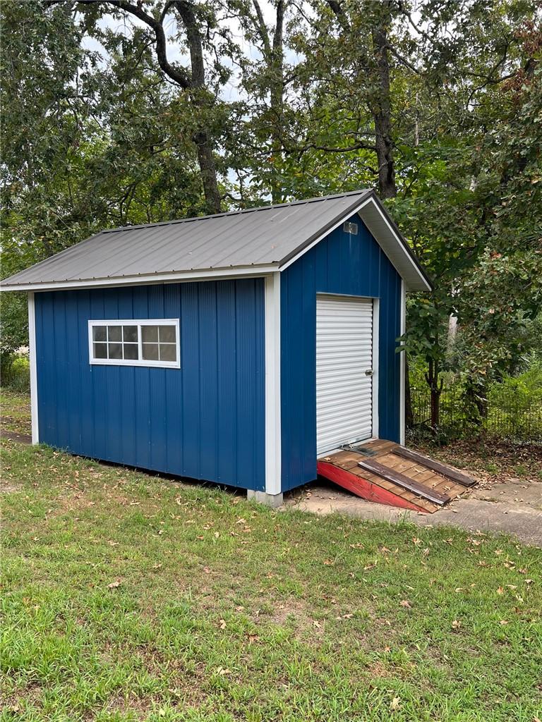 Image 2: Detached storage shed featuring blue vertical sidi