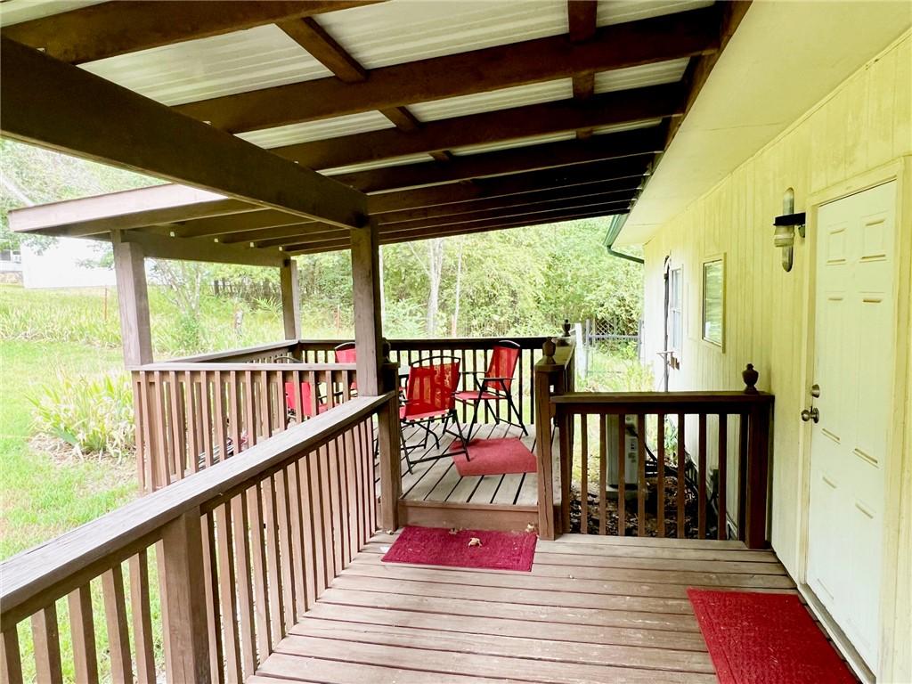 Image 4: Expansive covered wooden deck featuring a metal ro