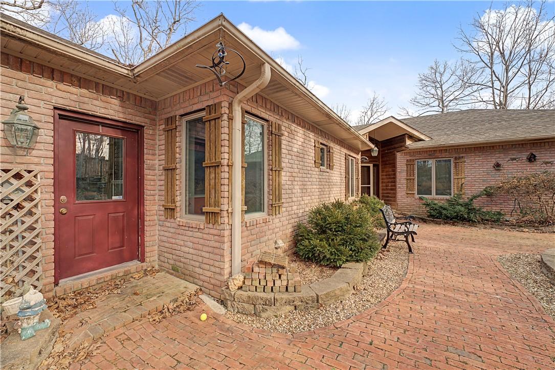 Image 2: Property entrance featuring brick siding and roof