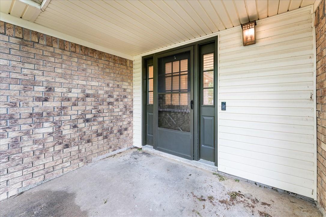 Image 3: Covered entry with brick and siding exterior