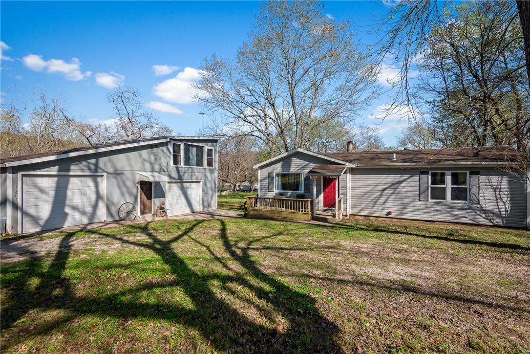 Image 4: Ranch-style residence featuring grey siding, a red