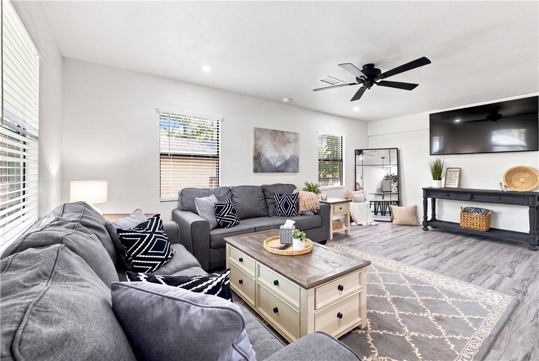 Image 2: Spacious living area featuring wood-finish floorin
