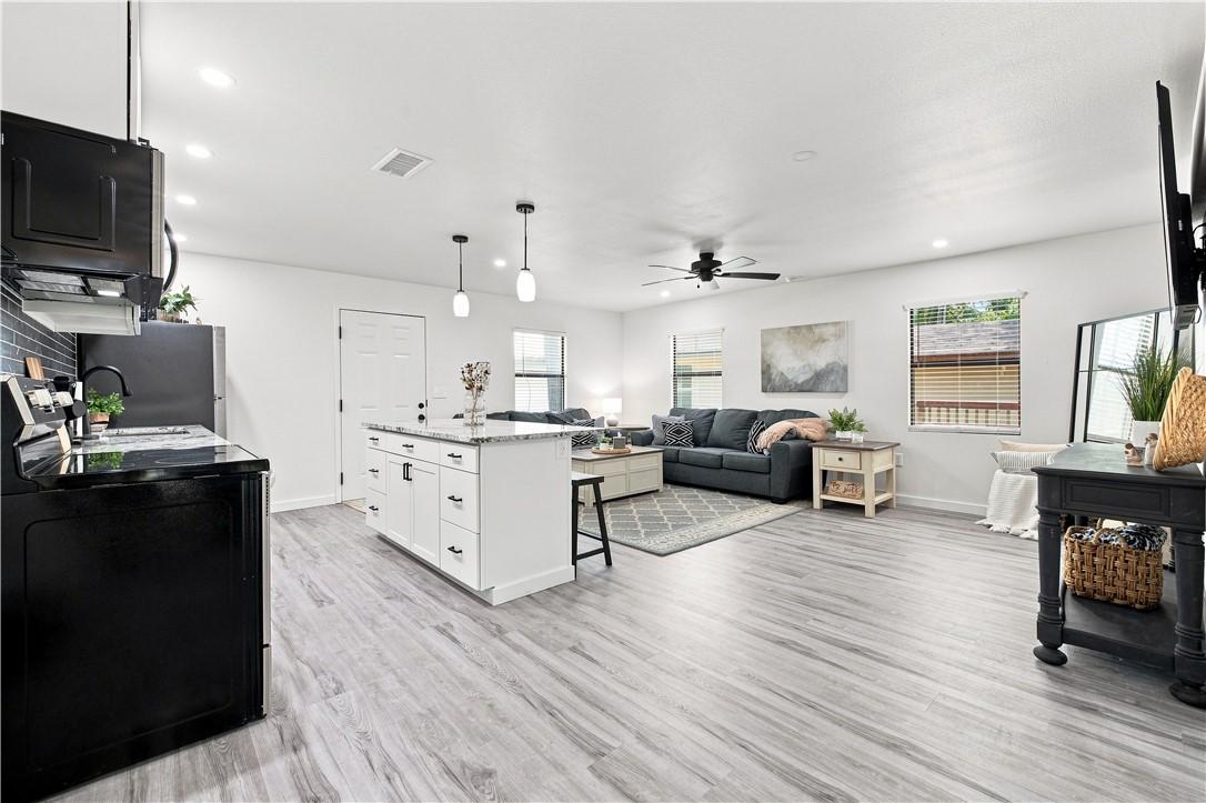 Image 3: Open-concept living space featuring wood-finish fl