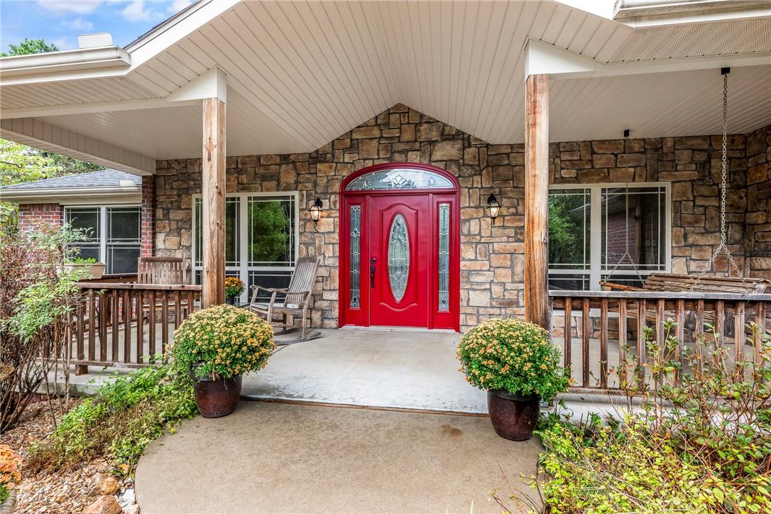 Image 4: Property entrance with stone siding and a wooden d