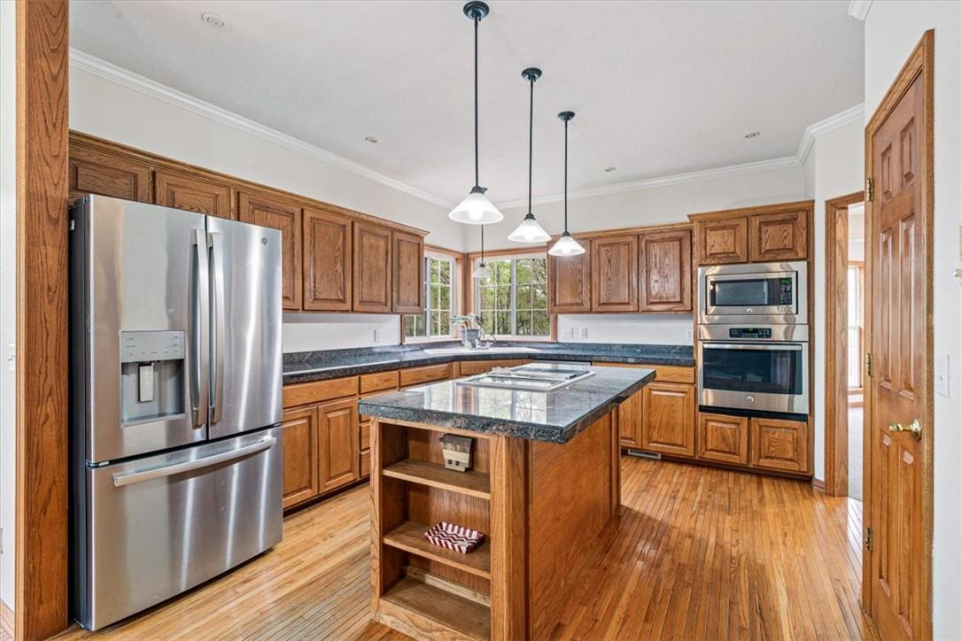 Image 4: The kitchen features wood cabinetry, a central isl