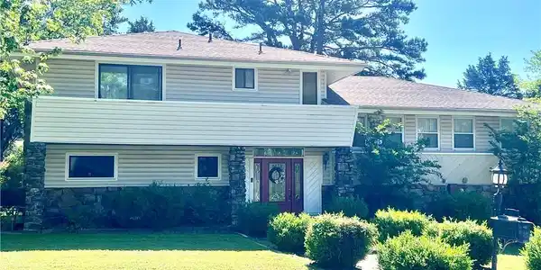 Image 2: Two-story residence featuring light-colored siding