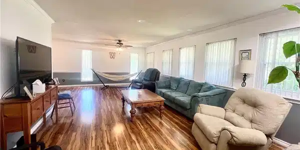 Image 3: Spacious living area featuring wood-finish floorin