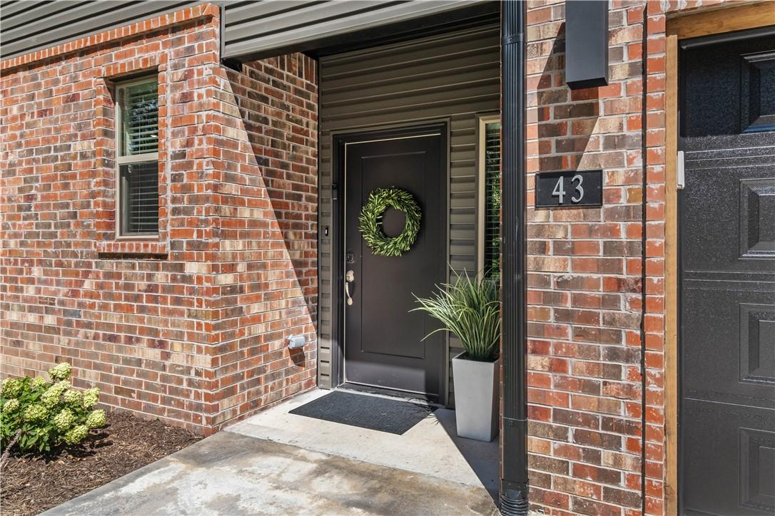 Image 3: Brick fa&ccedil;ade entryway featuring a black front door