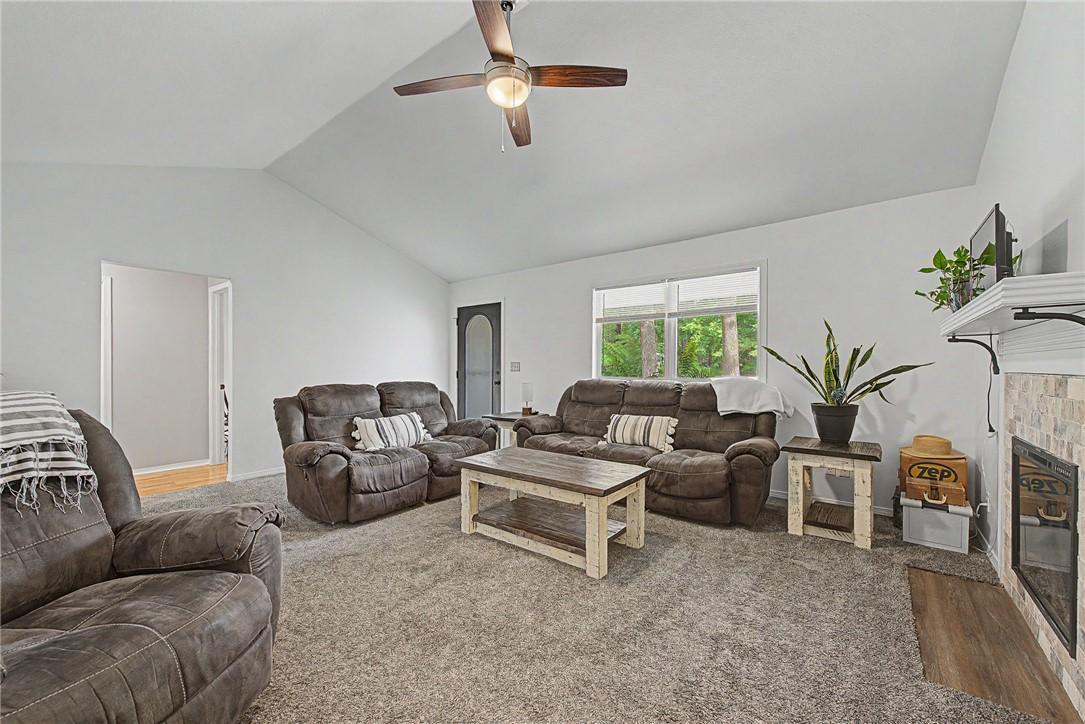 Image 4: Living area featuring  a fireplace with a tiled su