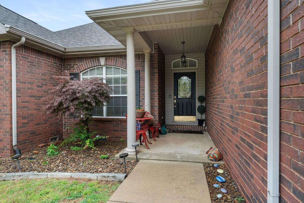 Image 2: Brick facade featuring a covered entry with white