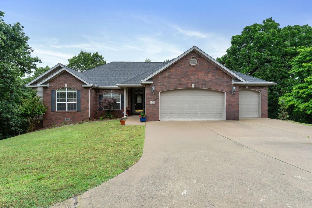 Image 3: Brick exterior with a prominent two-car garage and