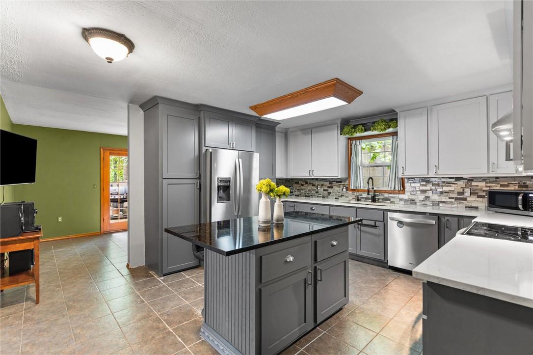 Image 2: Modern kitchen featuring grey and white cabinetry,