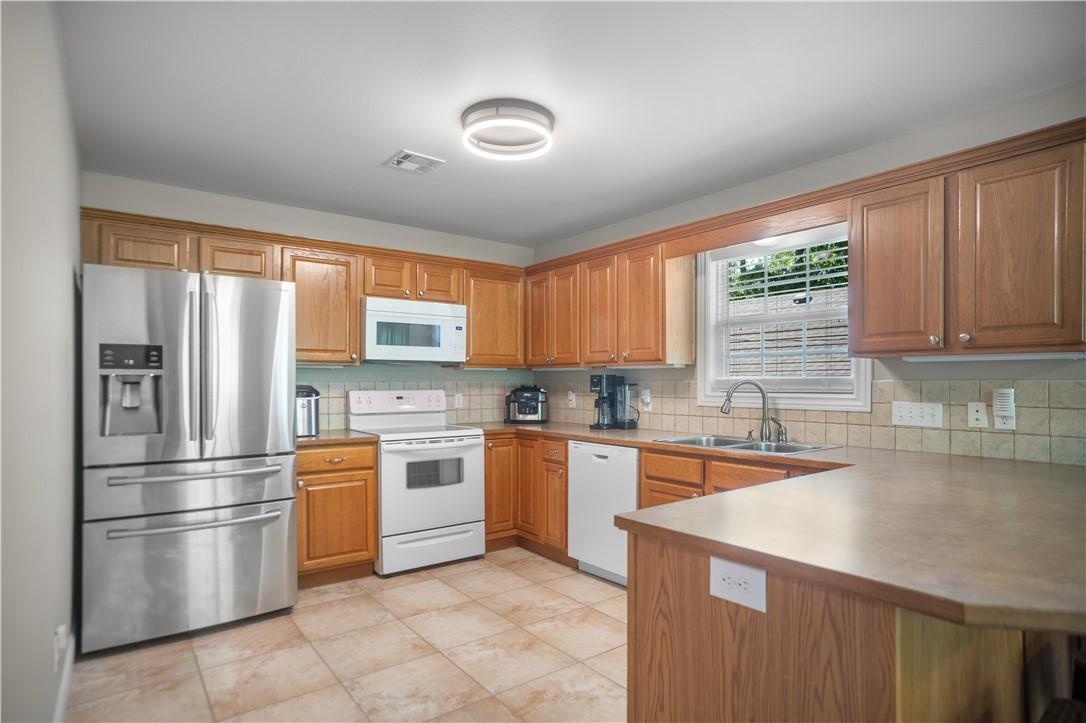 Image 2: Kitchen featuring wood cabinetry, stainless steel