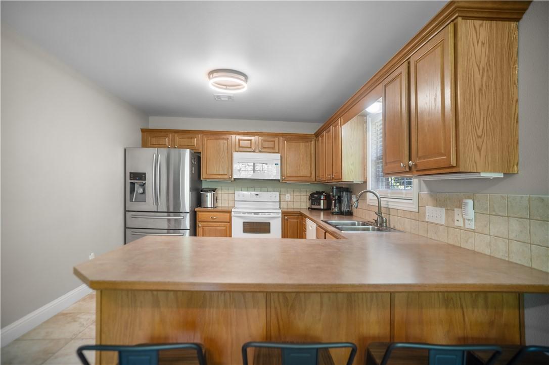 Image 3: Kitchen featuring a wood-finish peninsula with a d