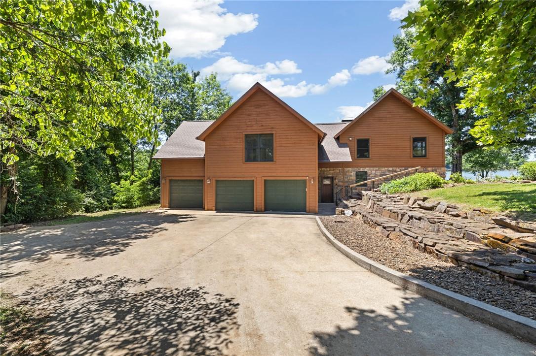 Image 3: Wood-sided exterior with stone accents, featuring