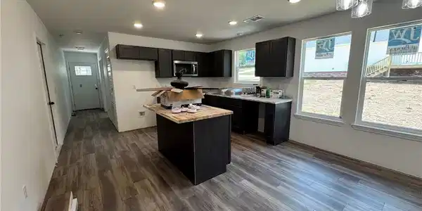 Image 3: Open concept kitchen and living area featuring woo