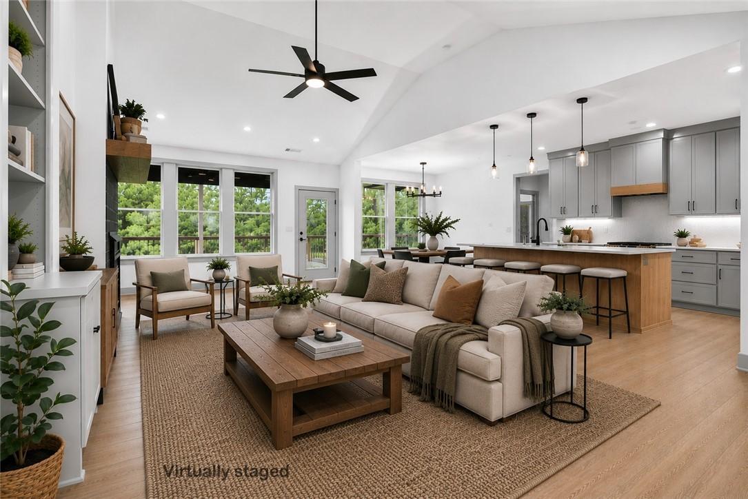 Image 2: Spacious living area featuring vaulted ceilings, w