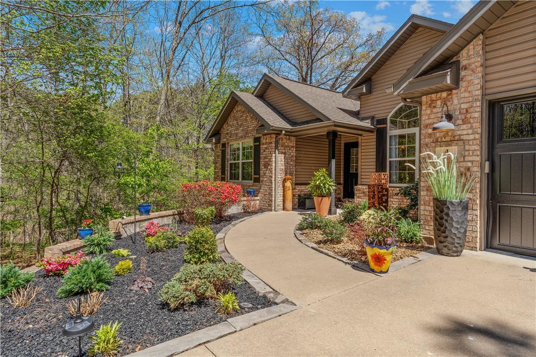 Image 3: Doorway to property featuring stone siding, a porc