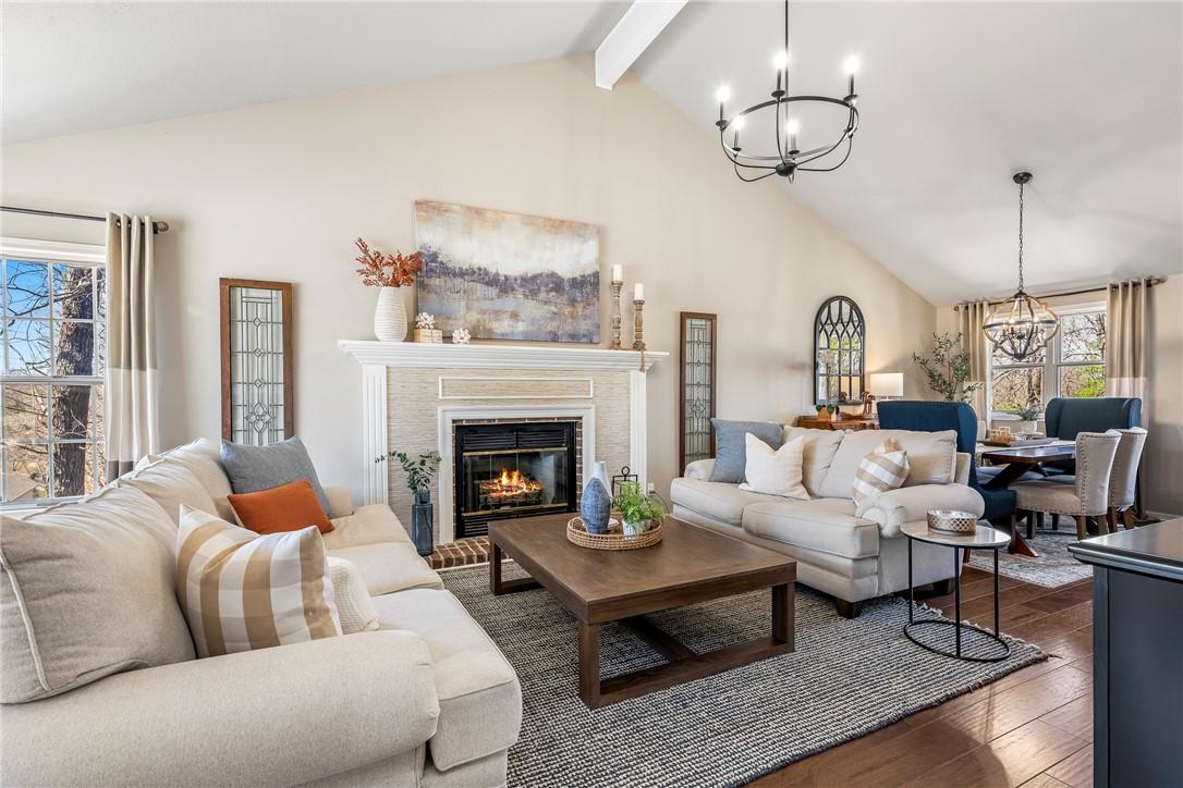 Image 2: Living area featuring a chandelier, wood flooring,
