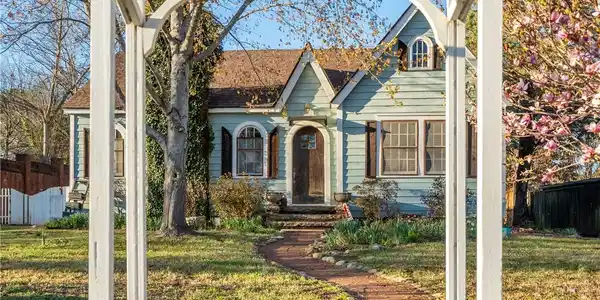 Image 2: Light blue siding cottage with a red brick pathway