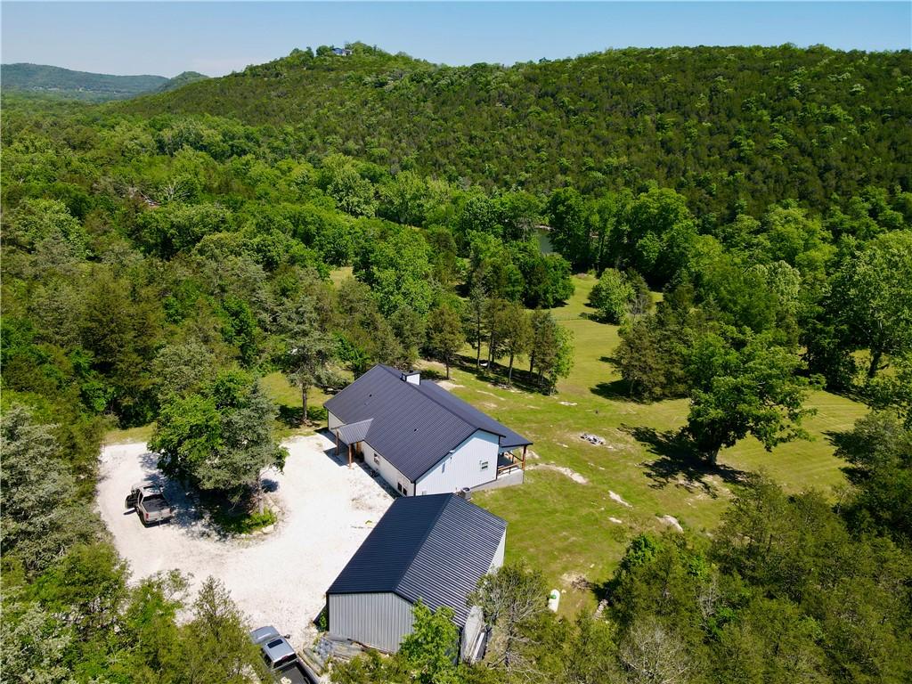 Image 2: Modern white residence with a dark metal roof, set