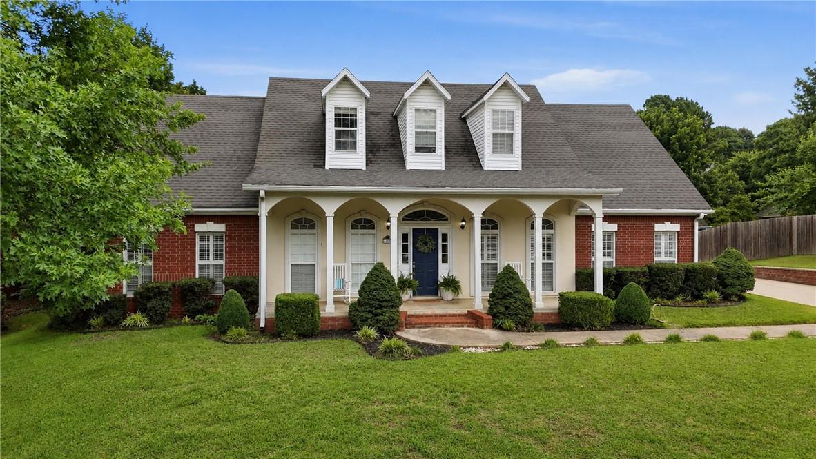 Image 1: Traditional brick residence featuring a prominent