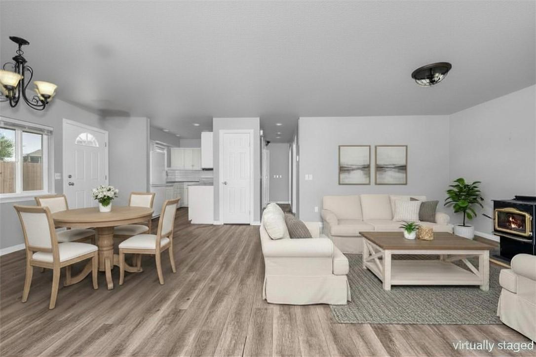 Image 2: Spacious open-concept living area featuring wood-f