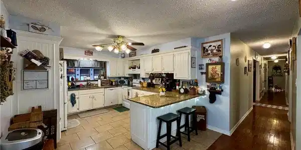 Image 3: Kitchen featuring a peninsula, a textured ceiling,