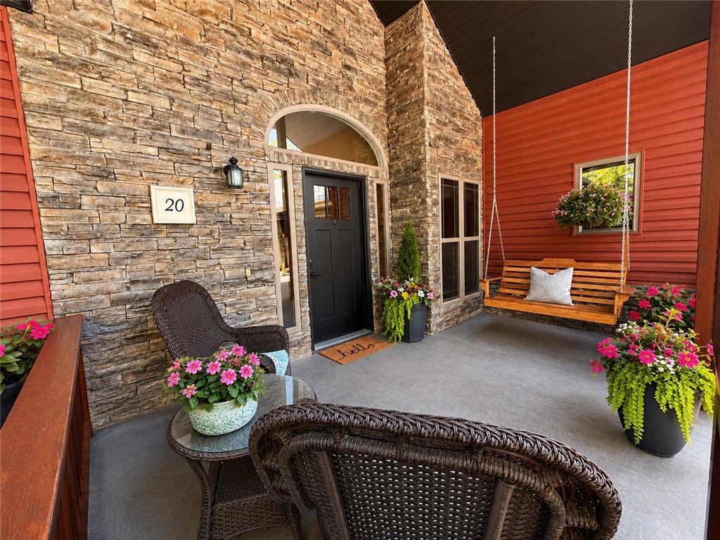 Image 4: Inviting covered porch with a stone facade, red si