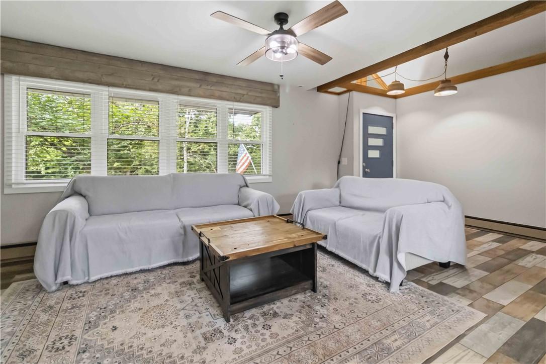 Image 2: Wood-finish flooring with exposed ceiling beams an