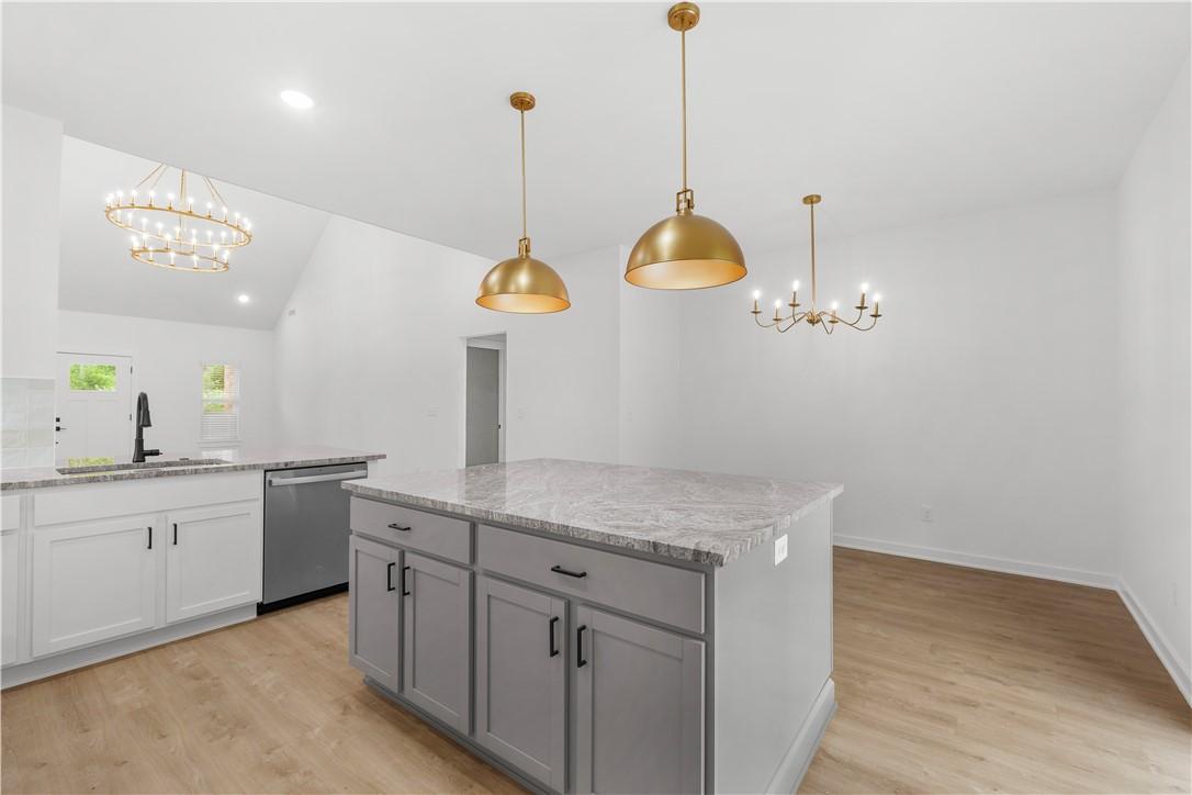 Image 2: The kitchen features light-colored cabinetry, a ce