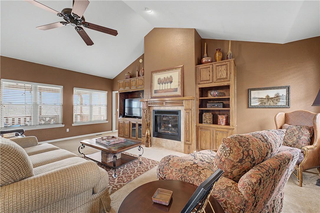 Image 2: Living area featuring ceiling fan, a tile fireplac