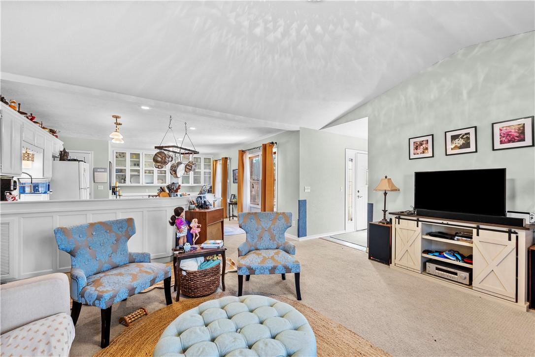 Image 3: Living area with carpet, lofted ceiling, and reces