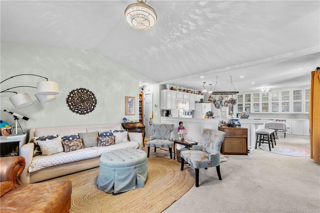 Image 4: Carpeted living room featuring lofted ceiling and