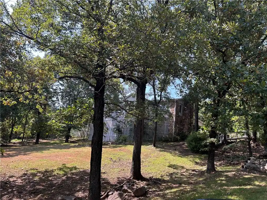 Image 1: Wooded property with mature trees and a stone-clad