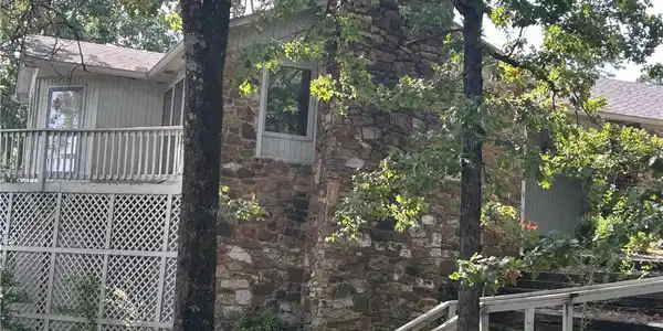 Image 2: Stone facade residence featuring multiple windows,