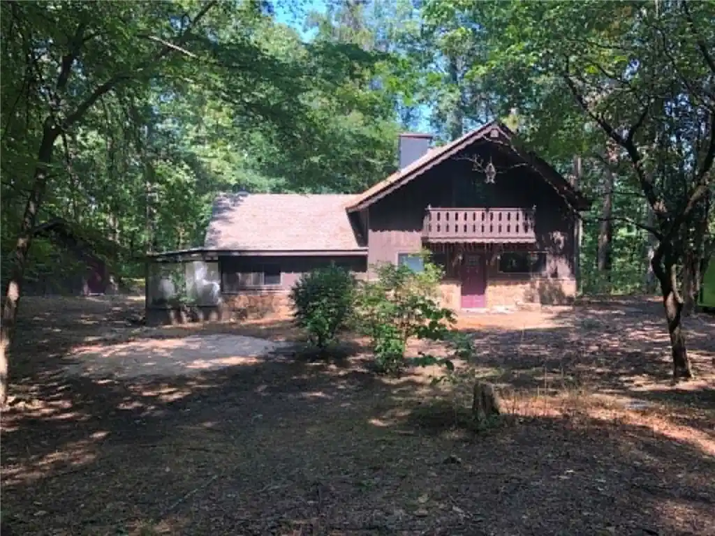 Image 1: Wood-sided exterior with a stone foundation, featu