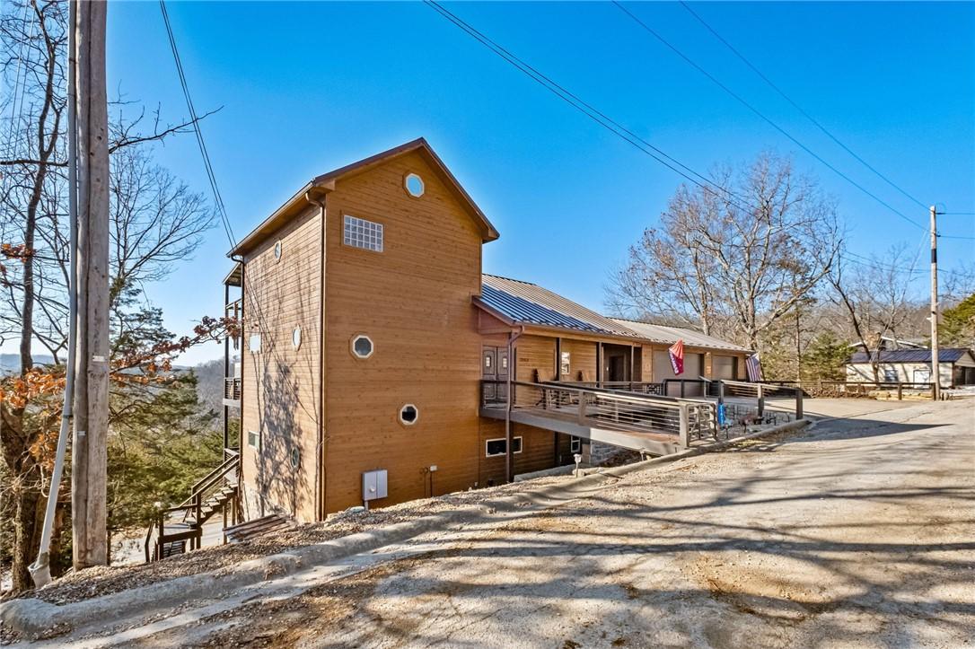 Image 3: View of side of home with a wooden deck, a metal r